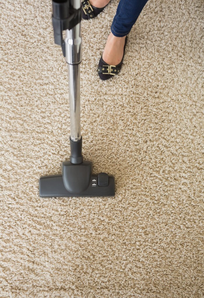 carpet being hoovered by woman