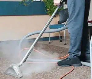 Rug And Carpet Cleaning Fairfax Va Astrobrite 3 Person using a steam cleaner on a carpet, with steam rising.